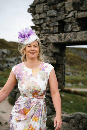 Ivory hat with purple feathers, veiled brim